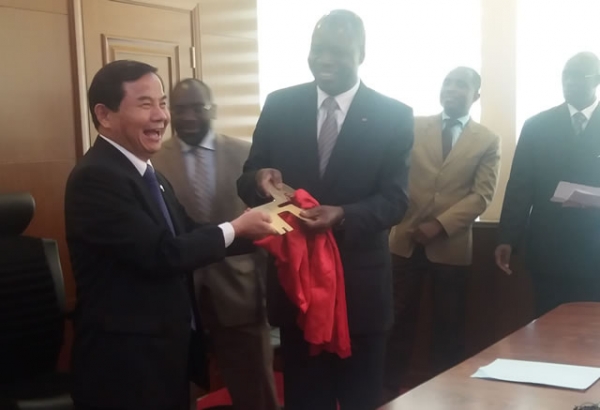 Le Ministre Mabri r&eacute;ceptionnant la cl&eacute; symbolique des mains de l'Ambassadeur Tang Weibin