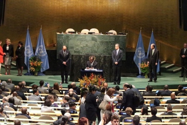 Le pr&eacute;sident Alassane Ouattara signant l'accord de la COP 21