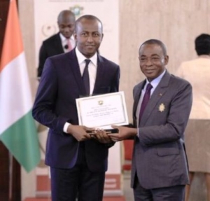 Le Pdg d' OPes Holding Siriki Sangar&eacute; , recevant son prix d'excellence 2016 du meilleur promoteur immobilier , des mains du Pr&eacute;sident du Ces , Charles Diby Koffi au nom du pr&eacute;sident de la R&eacute;publique , Alassane Ouattara