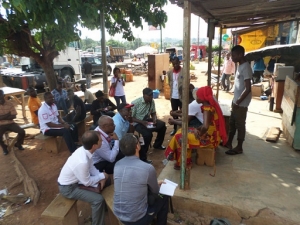 ne d&eacute;l&eacute;gation de Save The Children &eacute;changeant avec les b&eacute;n&eacute;ficiaires du PRAEJEM devant un atelier de couture